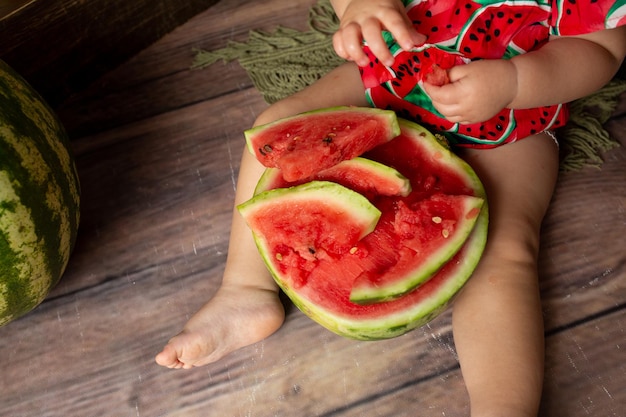 A baby eating a watermelon with the word watermelon on it