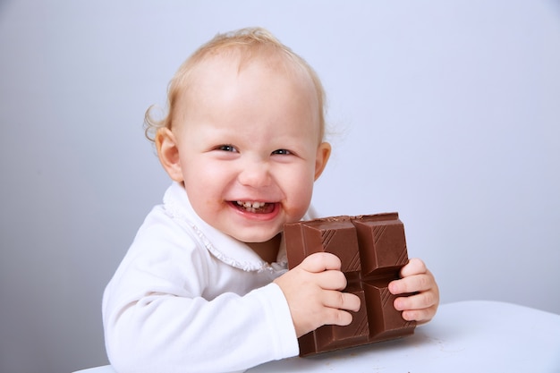 Baby eats a large bar of chocolate.