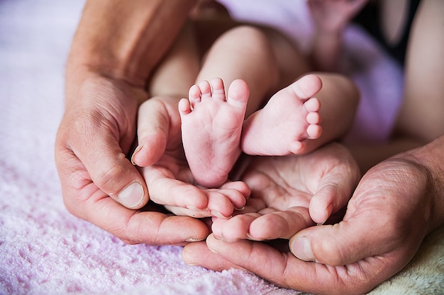 Baby feet in father hands on purple