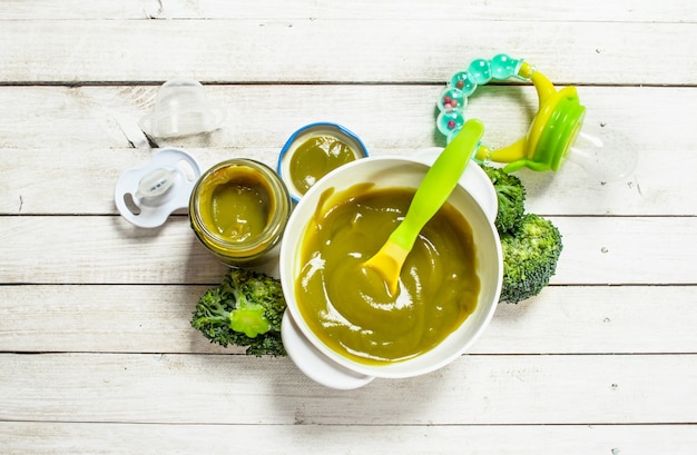 Baby food Baby puree from broccoli on a white wooden background