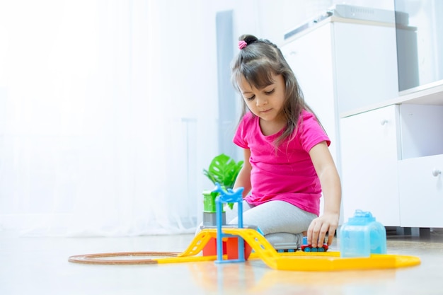 baby game. Little clever caucasian child playing colorful toy railway and train for early development. Preschooler kids leisure.