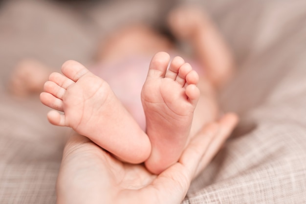 a baby girl in the arms of her mother on a light background