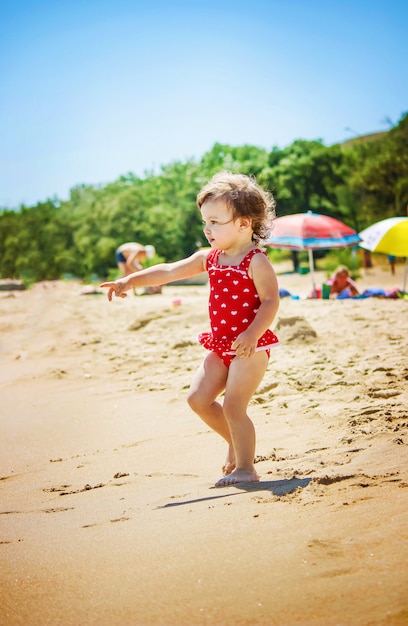 Baby girl on the beach, by the sea. Selective focus.