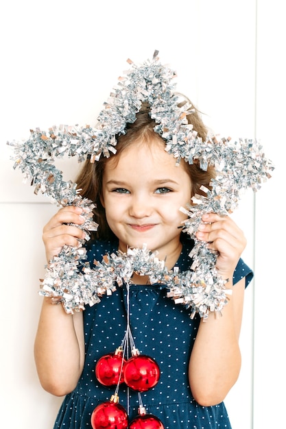 Baby girl in blue dress holding new year's Christmas decoration star