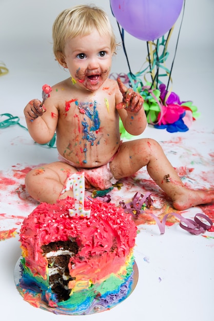 Baby girl celebrating her first bithday with gourmet cake and ba