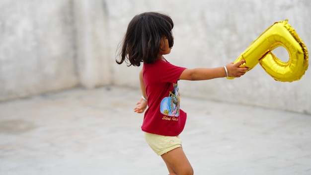 Baby girl dancing with p word balloon happy concept