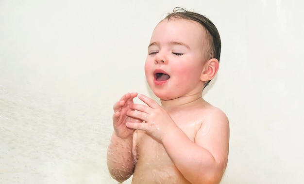 Baby girl having fun washing in bath.