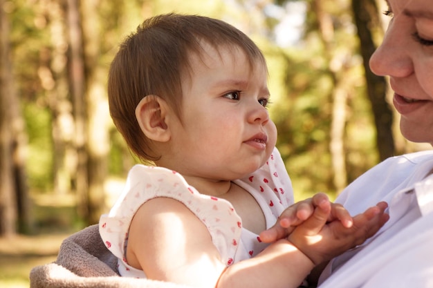 baby girl in her mother's arms clapping her hands