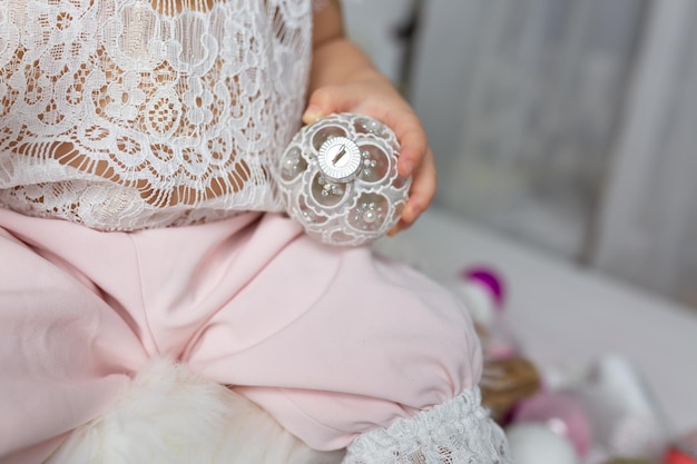 A baby girl holding a glass ball in her hands