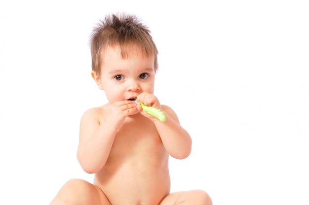 Baby girl holding her first green toothbrush