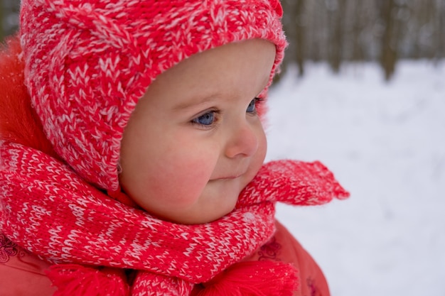 Baby girl impressed with the snow. Close-up.