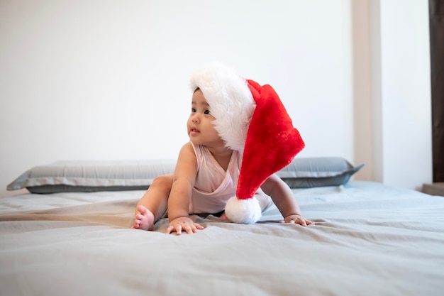 Baby girl laughing wearing santa claus hat at home