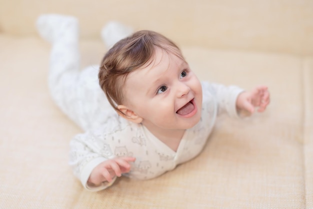 Baby girl lying on the couch and smiles