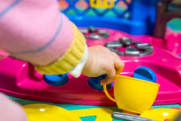 Baby girl play with plastic kitchen toys