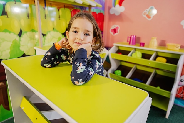 Baby girl playing at indoor kids kitchen playground