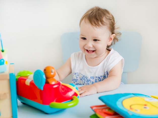 Baby girl playing with educational toy in nursery