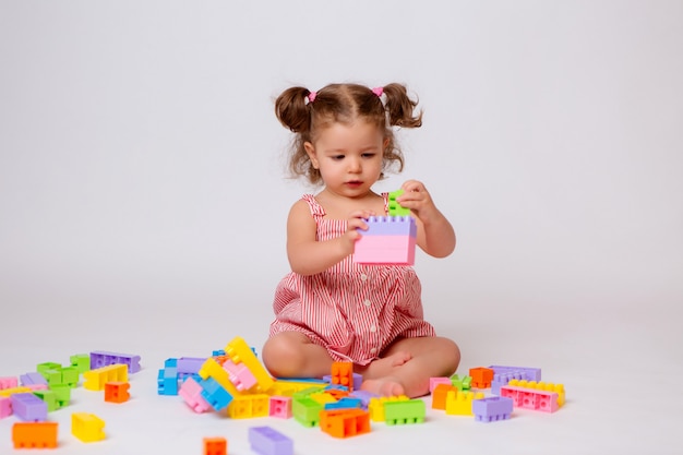 baby girl playing with multicolored constructor 