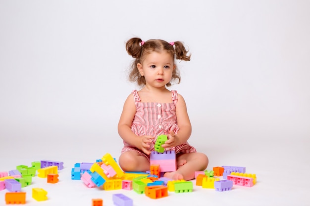 baby girl playing with multicolored constructor 