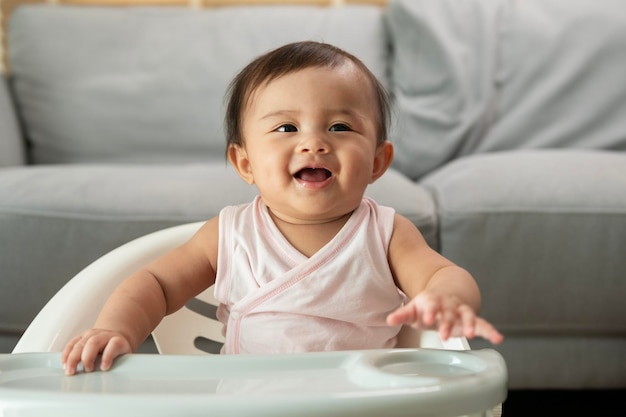 A baby girl ready for eating blend food on baby chair