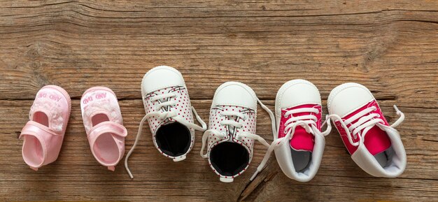 Photo baby girl shoes variety on wooden background top view