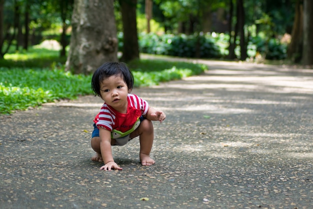 A baby girl start walking first on the park