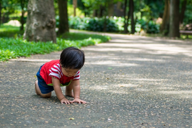 A baby girl start walking first on the park