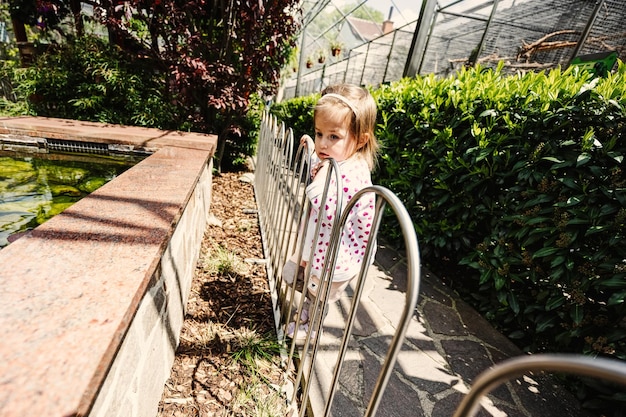 Baby girl visit parrot zoo in sunny day