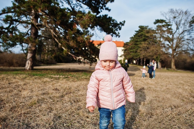 Baby girl wear pink jacket walking at Valtice park Czech Republic