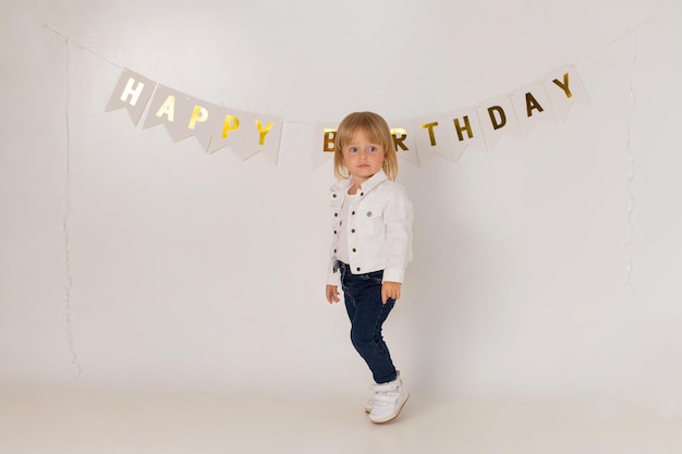 Baby girl on a white background with the inscription happy birthday.