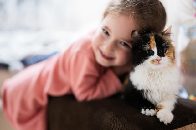 Baby girl with kitty lying on the sofa Children's love for pets