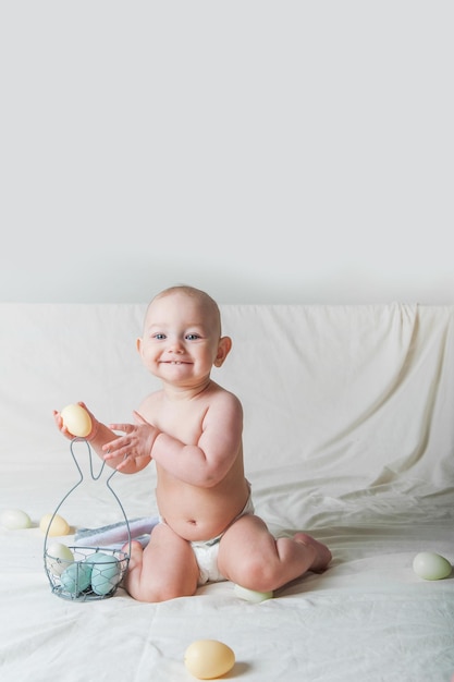 Baby girl year old on bed with basket and easter eggs egg hunting kids activity