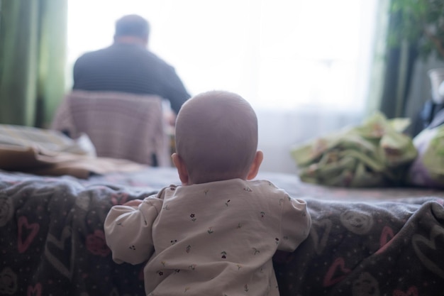 Baby gril looking on her father working at home