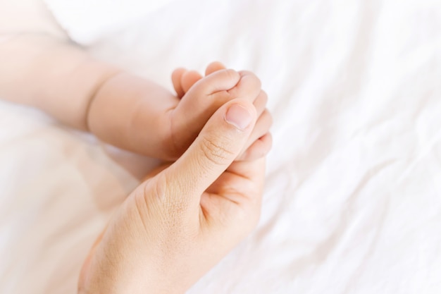 baby in the hand of mother close up, Parent holds Baby Hand Closeup