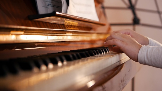 A baby hands playing piano on music lesson in school