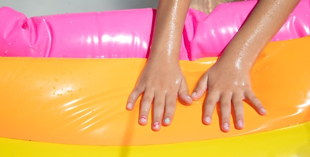 Baby hands in the water in the inflatable pool