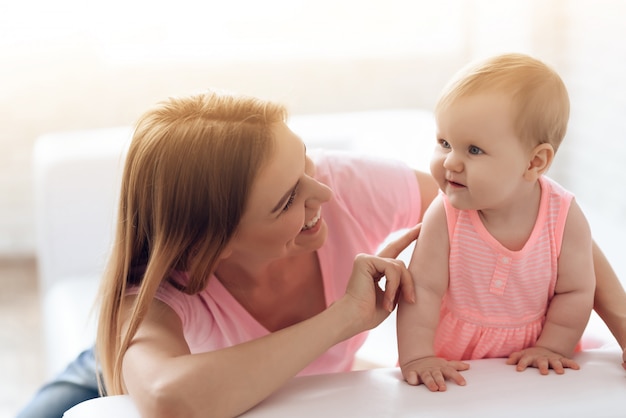 Baby hugging with cheerful young smiling mother