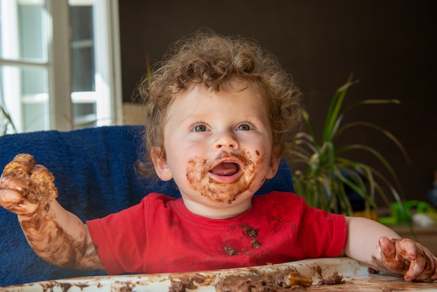 Baby is eating a chocolate cake