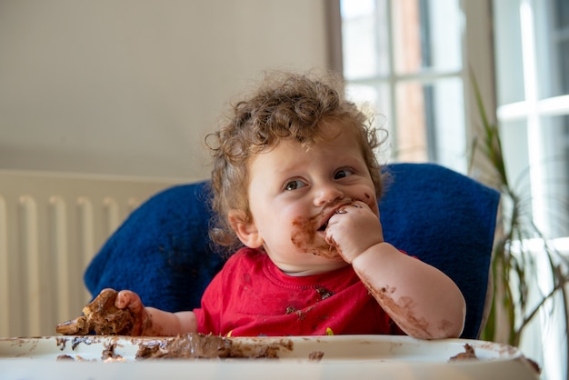 Baby is eating a chocolate cake