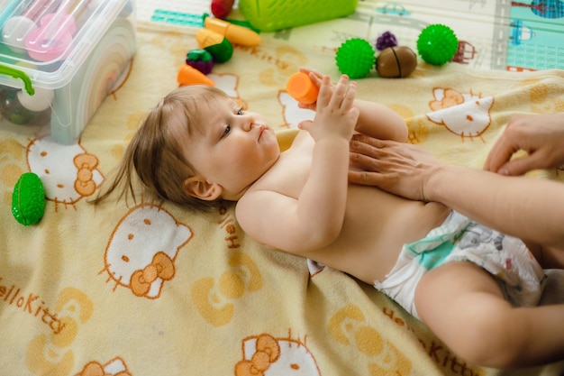 A baby is lying on a bed with a blanket that says'baby'on it '