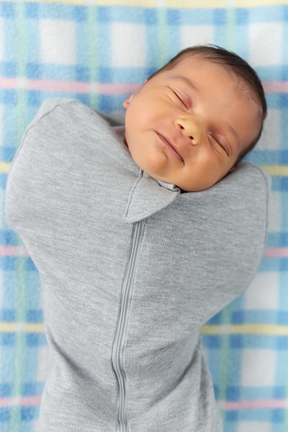 The baby is lying in a cocoon on cot He sleeps sweetly and dreams