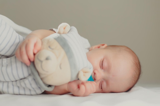 The baby is lying in his crib and looking at the camera A happy child Children's article