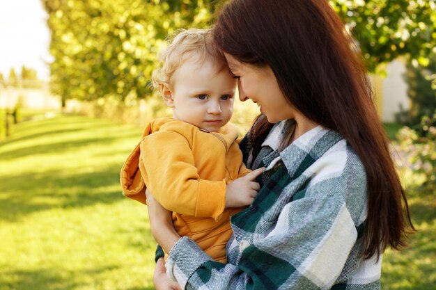 Photo the baby is sad in the arms of his mother for a walk