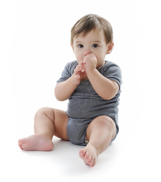 Baby is sitting on floor, isolated on white