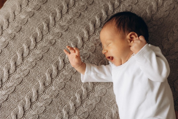 a baby is sleeping on a carpet with a pattern on it