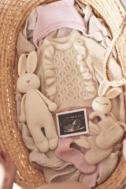 Baby knitted clothes in wicker basket Preparation for childbirth