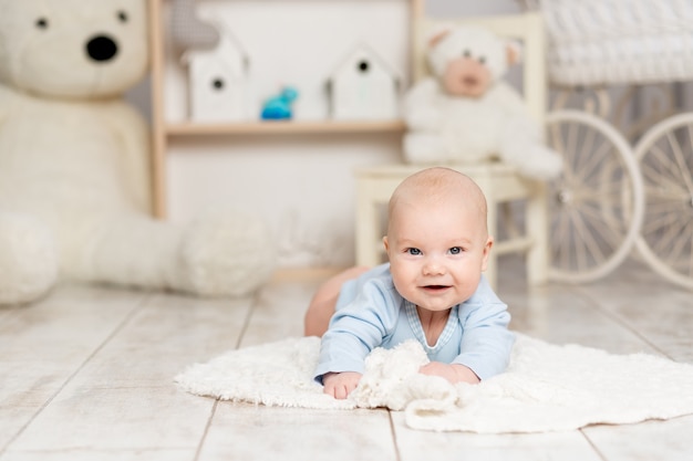 Baby lies at home in the children's room with toys, development concept and games