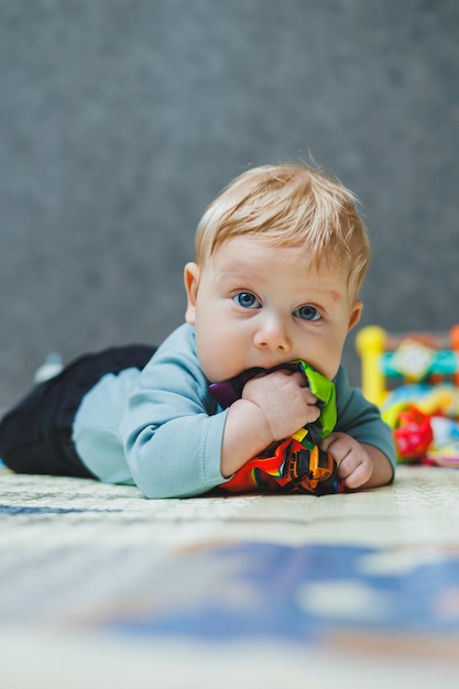 The baby lies on a thermal mat and plays Selfdevelopment of a newborn child Toys for child development