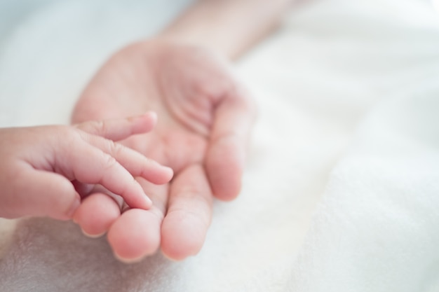 Baby new born hand in mother hand : Concept of love, Take Care, Protecting