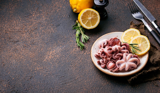 Baby octopus in plate with lemon and rosemary