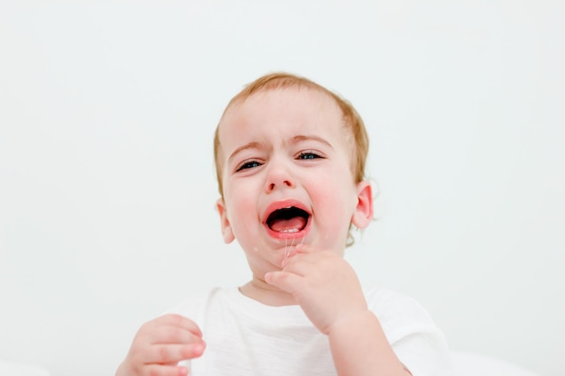 baby open mouth with milk teeth. Drool is drooling from his mouth. concept of painful teething, childrens crying